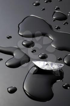 paper boat floating on water drops over black background