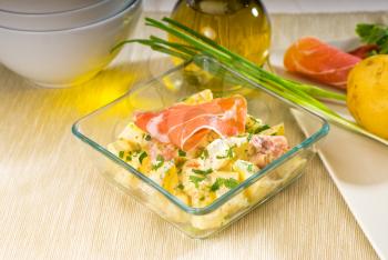 fresh home made parma ham and potato salad,with raw ingredients around with bowls and dishware on a table