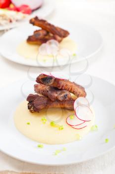 traditional Italian roasted pork ribbs served on polenta bed,corn cream