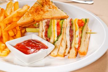 fresh triple decker club sandwich with french fries on side