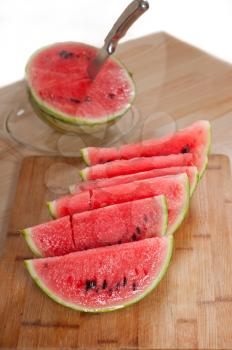 fresh ripe watermelon sliced on a  wood table with knife