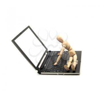 wood mannequin sitting on a laptop isolated on white background