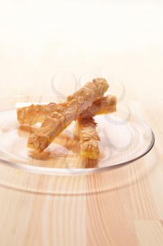 sunflower seeds puff pastry sticks on a glass transparent plate over pine wood table
