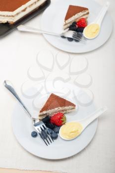 classic Italian tiramisu dessert with berries and custartd pastry cream on side 