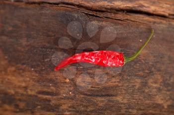 dry red chili peppers over old wood table 