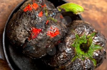 three fresh bell peppers charcol scorched  over old wood table on a skillett