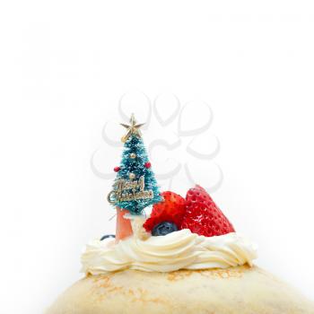 christmas tree on top of a pancake crepe mountain with whipped cream and strawberry