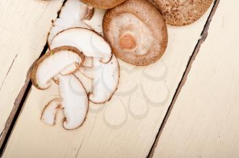 fresh shiitake mushrooms on a rustic wood table 