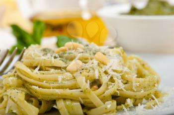 Italian traditional basil pesto pasta ingredients parmesan cheese pine nuts extra virgin olive oil garlic on a rustic table 