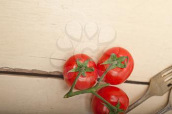 ripe cherry tomatoes cluster over white rustic wood table