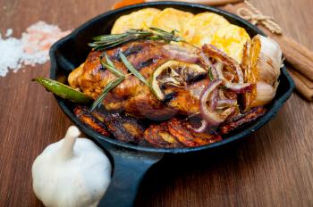 roasted grilled BBQ chicken breast with herbs and spices rustic style on iron skillet