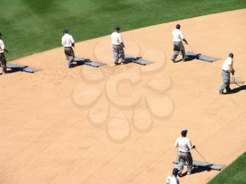 Royalty Free Photo of People Dragging a Baseball Field