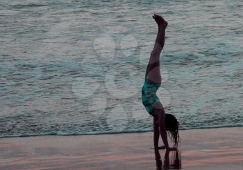 Royalty Free Photo of a Little Girl Doing A Handstand On The Beach