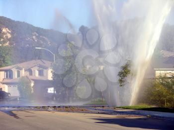 Royalty Free Photo of a Water Main Exploding In A Neighborhood