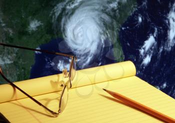 Royalty Free Photo of a Notebook and Map Tracking a Hurricane