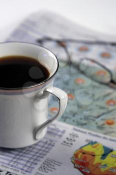 Royalty Free Photo of a Cup of Coffee and a Newspaper