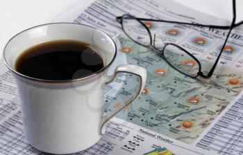 Royalty Free Photo of a Cup of Coffee and Newspaper