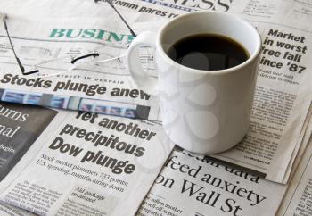 Royalty Free Photo of a Cup of Coffee and Newspaper