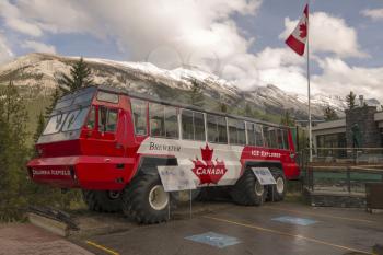 One of the Columbia Icefield vehicles parked in front of the Banff Gondola base building.