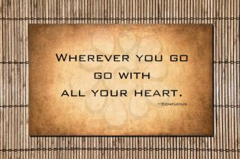 Over bamboo and a golden grunge background, the profound Confucius quote wherever you go go with all your heart.