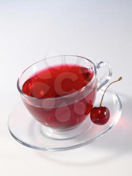Royalty Free Photo of a Tea With a Cherry on the Saucer