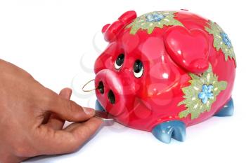 Royalty Free Photo of a Person Putting Money Into a Piggy Bank