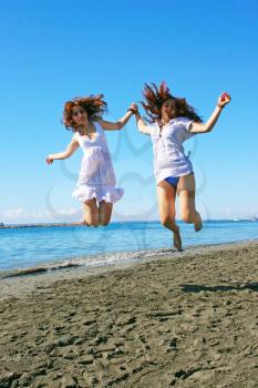 Royalty Free Photo of Two Women Jumping on the Beach