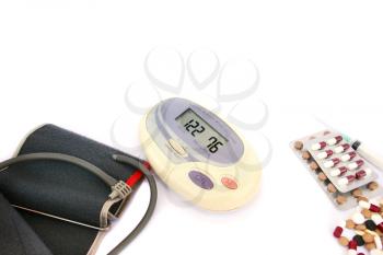 Royalty Free Photo of a Digital Blood Pressure Measurement and Pills