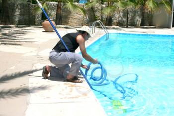 Royalty Free Photo of a Man Cleaning a Swimming Pool