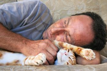 Royalty Free Photo of a Man Cuddling a Cat
