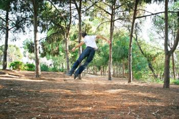 Royalty Free Photo of a Man Jumping by Trees