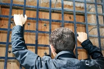 Royalty Free Photo of a Person Looking at a Gated Door