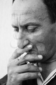 Royalty Free Photo of a Man Smoking a Cigarette