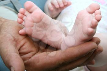 Royalty Free Photo of a Father Holding His Baby's Feet