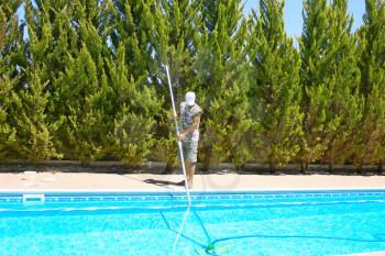 Royalty Free Photo of a Man Cleaning a Swimming Pool