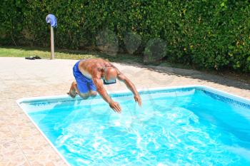 Royalty Free Photo of a Man Jumping into a Swimming Pool