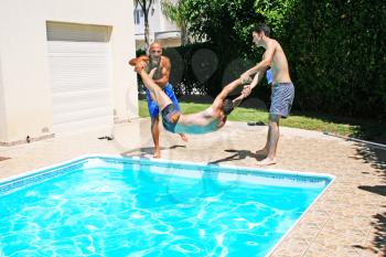 Royalty Free Photo of Men Throwing Their Friend into a Pool