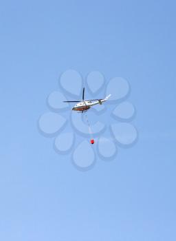 Royalty Free Photo of a Helicopter With a Water Tank