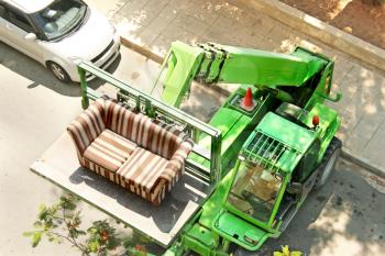 Royalty Free Photo of a Couch Being Lifted By a Tractor