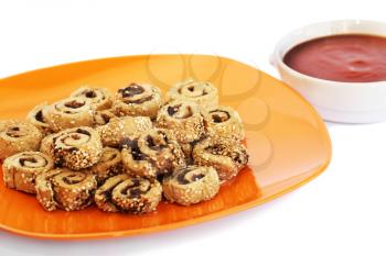 Rusks with sesame seeds, olives on orange plate and red sauce isolated on white background.