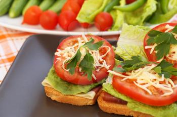 Sandwiches with bacon, lettuce, tomato and cheese on plate.