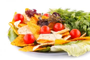 Nachos, cherry tomatos, lettuce, herbs in plate on white background.