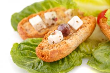 Rusks, feta cheese and vegetables on white background.
