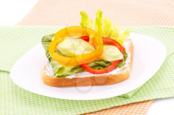 Sandwich with rusks, vegetables, cheese in plate on towels.