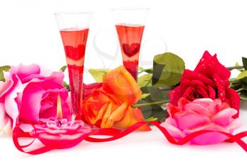 Roses, candles, red ribbon and two glasses isolated on white background.