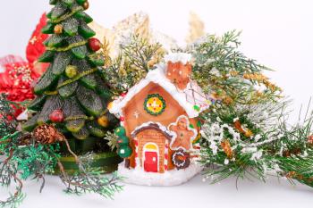 Fir tree candle and toy house on gray background.