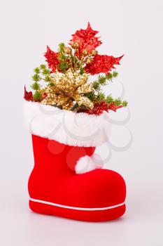 Christmas decoration in Santa's red boot isolated on gray background.