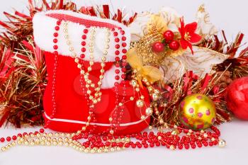 Christmas decoration with Santa's red boot, garland, beads closeup picture.