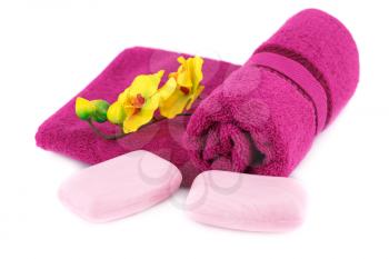 Rolled towel, flowers and soaps isolated on white background.