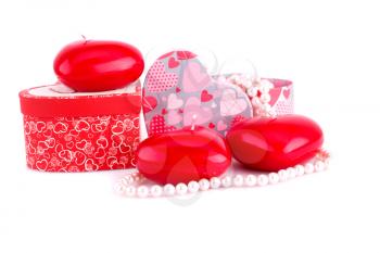 Red heart candles, necklaces and gift boxes on white background.